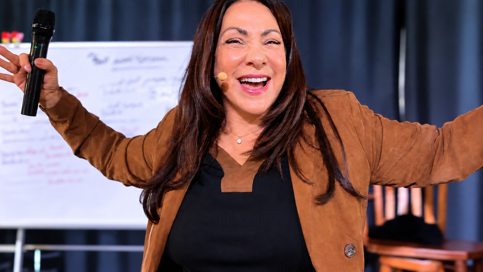Dolly Demitro, micro à la main, bras ouverts en pleine formation